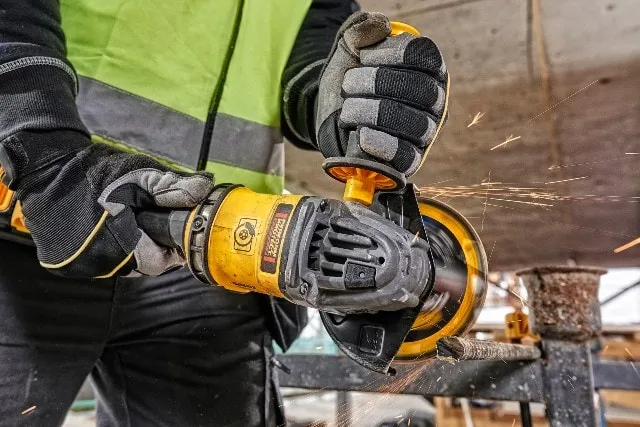 man works with DEWALT grinder