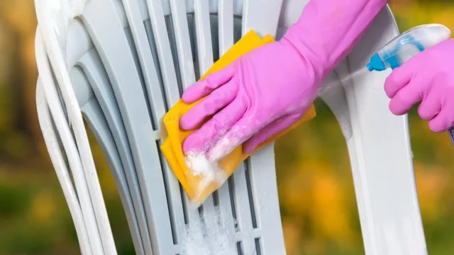 woman cleaning plastic garden chair