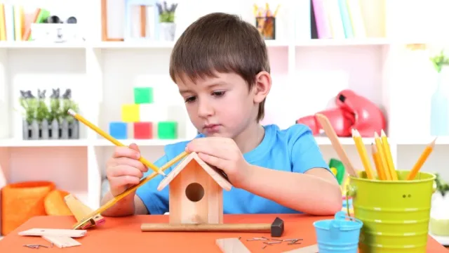 little boy making a birdhouse