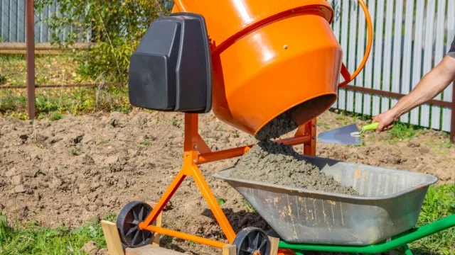 man leegt betonmolen in kruiwagen