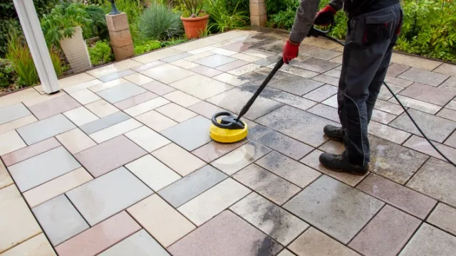 man reinigt betontegelterras
