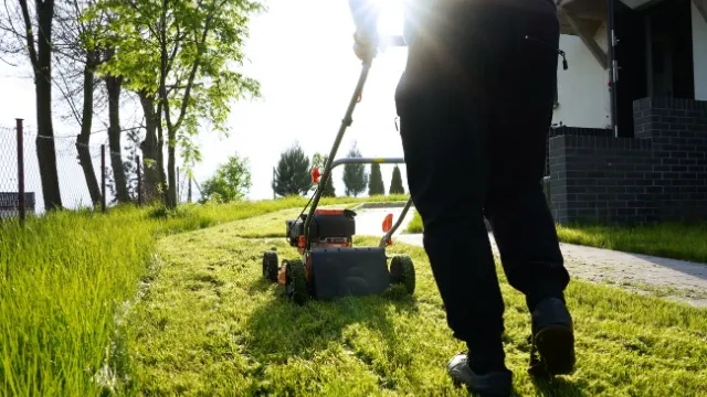 man mows grass