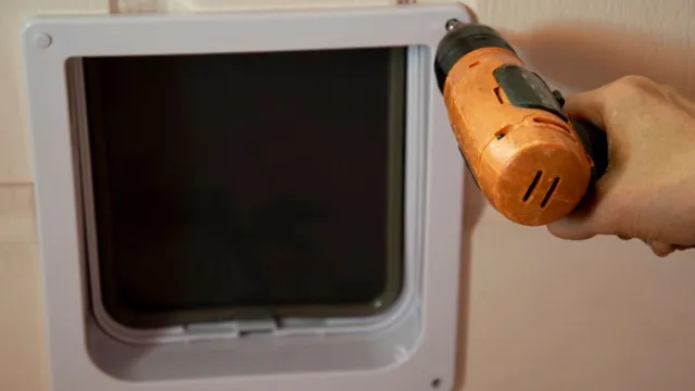 man schroeft luik vast met schroefboormachine