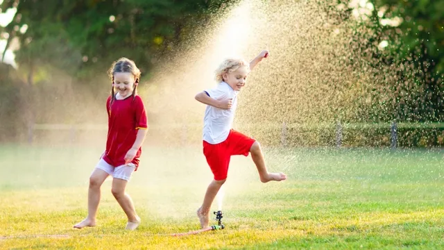kinderen spelen met tuinsproeier