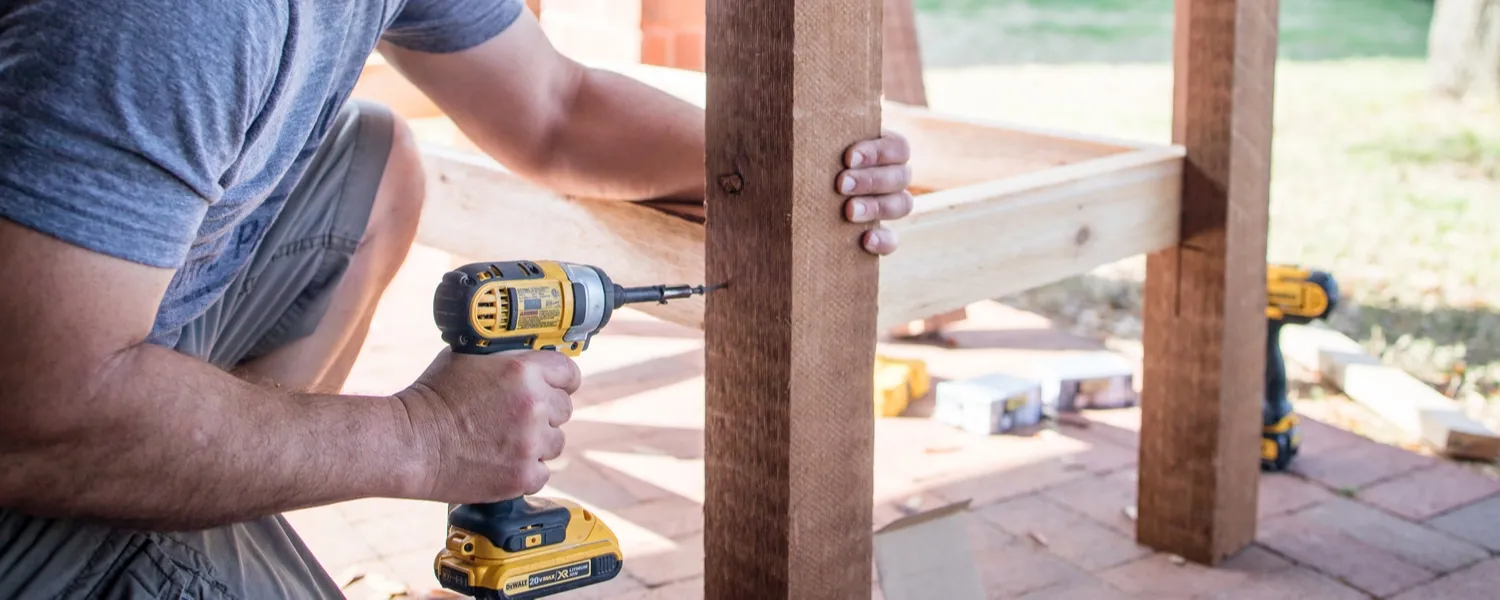 man works with DeWalt cordless drill