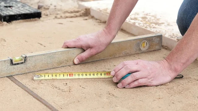 man controleert zandbed met waterpas