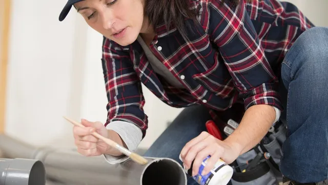 woman glues PVC pipe