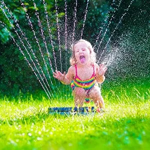 kind speelt met tuinsproeier