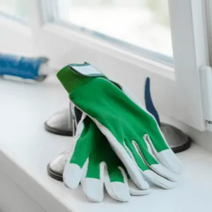 caulking gun and work gloves in windowsill